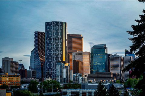 Downtown Calgary skyline with the iconic Calgary Tower illuminated at blue hour.